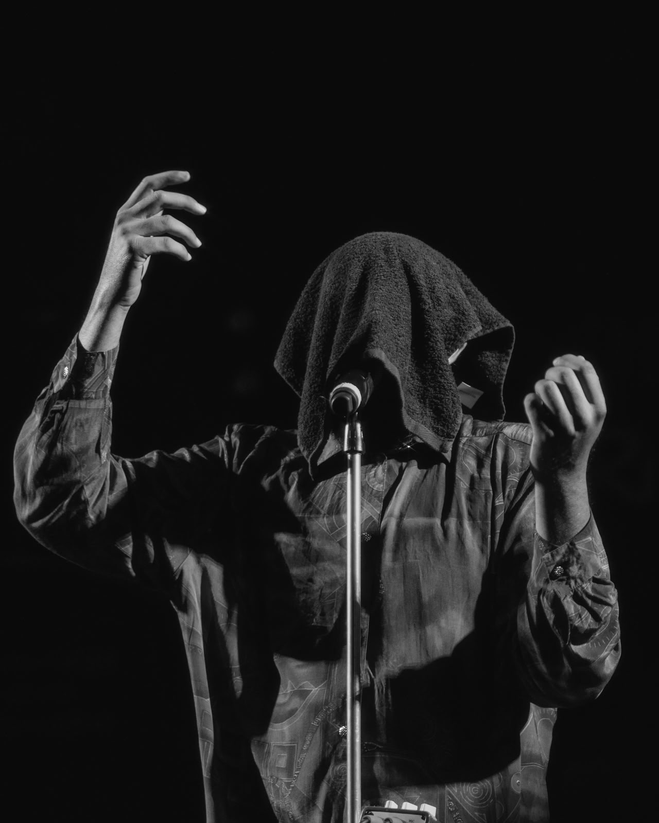 Cantante — asciugamano in testa, mani che artigliano l'aria